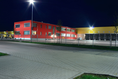 Die leuchtende Fassade in Rot und Gelb des DHL Freight-Standorts in Malsfeld ist auch bei Nacht von weitem gut zu erkennen