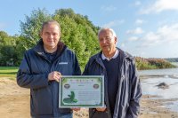 LAV-Vizepräsident Klaus-Dieter Mau (re.) überreicht WEMAG-Vertriebsleiter Michael Hillmann die Aalaktie. Foto: WEMAG/Stephan Rudolph-Kramer