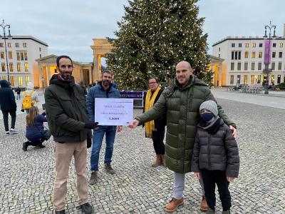 Michael Veit (vorne rechts) überreicht Itay Novik den symbolischen Spendenscheck über 5.000 €. Hinten: Björn Trautwein (B.Z.) und Susanne Weiß, Geschäftsführerin des Projektträgers MORUS14 e.V. Bildquelle: lekker Energie
