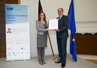 Lisa Schulz, Global Process Manager bei HARTING, nahm den Preis Uwe Beckmeyer, Parlamentarischer Staatssekretär beim Bundesminister für Wirtschaft und Energie, entgegen