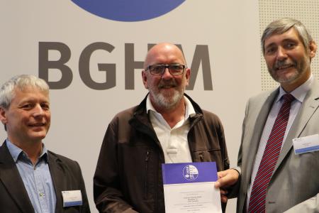 Die Präventionsexperten Andreas Franzki und Ralf Heinrici der BGHM übergeben das Gütesiegel an Thomas Kienast (Mitte) von der gleichnamigen Tischlerei aus Scheden bei Göttingen.