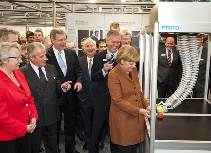 Bundeskanzlerin Dr. Angela Merkel überreicht im Beisein des italienischen Wirtschaftsministers Claudio Scajola und Dr. Eberhard Veit, Vorstandsvorsitzender der Festo AG, dem Bionischen Handling-Assistenten von Festo einen Apfel