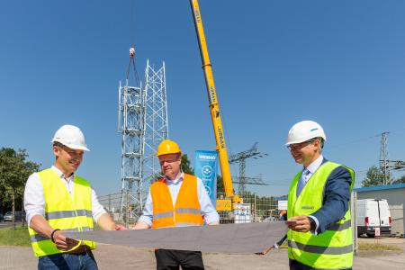 Michael Hammes, Bereichsleiter Mobilfunkmastbau bei Cteam, Projektleiter Karsten Schiller und WEMAG-Vorstand Thomas Murche (v.l.) besuchen die Endmontage des 450-MHz-Funkmastes am Umspannwerk Zarrentin. Foto: WEMAG/Stephan Rudolph-Kramer