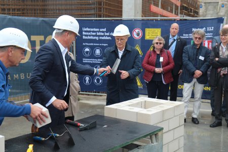 Unser Foto zeigt unseren Bauherrn Fabian von Köppen bei der Übergabe der Kelle an den Hamburger Oberbürgermeister Peter Tschentscher. Im Hintergrund schauen zu: die Brandschützerin Christiane Hahn, der Architekt Jan Störmer und der Geschäftsführer HafenCity Giselher Schultz-Berndt.