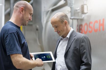 Bosch-Kundendiensttechniker Heiko Doppler zeigt Thomas Steffes von der ausführenden Firma Kramer & Best die verschiedenen Menüebenen von MEC Optimize. Der Effizienzassistent liefert künftig die Daten an die zentrale Leitwarte der Brauerei. (Bild: Bosch Industriekessel)