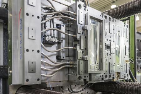 Injection mold in which injection molded parts are provided with an in-mold decorative design and PUR topcoat by means of Kurz's IMD PUR technology (Photo: Kurz)