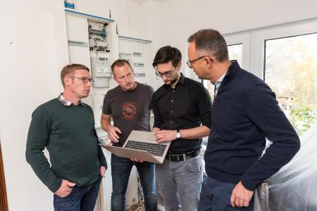 WNG-Mitarbeiter Karl-Kristian Rost, WNG-Geschäftsführer Andreas Haak, WNG-Mitarbeiter Moritz Koch und Niederlassungsleiter Viessmann Deutschland GmbH in Stäbelow, Steffen Wurz (v.l.) testen und prüfen die Schaltbefehle zwischen dem Messsystem und der Wärmepumpe (Foto: WEMAG/Stephan Rudolph-Kramer)