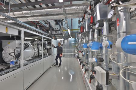 Blockheizkraftwerk und Warmwasserspeicher im Untergeschoss des Fraunhofer IISB: Die Kraftwärme-Kopplungsanlage wurde im Rahmen des Erweiterungsbaus B in die Infrastruktur des Instituts integriert. Dort wird sie sowohl zur Wärme- und Stromversorgung als auch als Forschungsanlage genutzt. Bild: Kurt Fuchs / Fraunhofer IISB