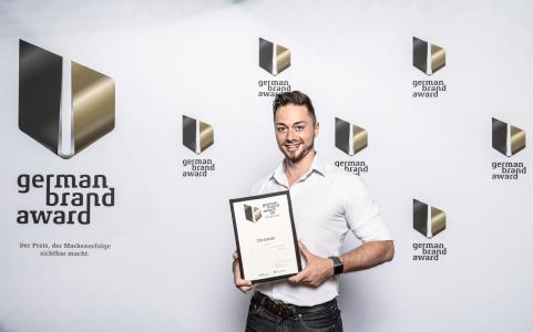 Dominic Fischer, Eventmarketing Manager bei Dematic, nahm gestern in Berlin den German Brand Award für Dematic entgegen. (Foto: German Brand Award)