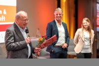 Starkmacher-Förderer Michael Hahn (l.) richtete bewegende Worte an das Publikum. Im Hintergrund: ISOTEC-Geschäftsführer Horst Becker und Stark ins Neue-Gründerin Julia Keltsch.