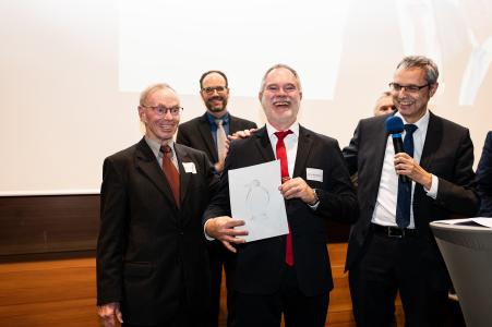 Zum 10-jährigen Bestehen des Graduate Campus überreichte Rektor der Hochschule Aalen, Prof. Dr. Gerhard Schneider (r.), den „Pinguin“-Preis an Prof. Dr. Ulrich Schmitt (2.v.r.) und Prof. Dr. Peter Gerloff (l.) für ihren Mut, vorauszugehen und sich in unbekannte Gewässer zu wagen /Bildhinweis: Hochschule Aalen / Sandro Brezger