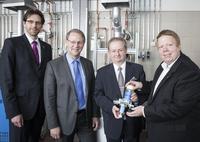 Der AFRISO Produktmanager Markus Schuster (re) überreicht Hauptgeschäftsführer Prof. Dr. Forster (2.v.re) anlässlich der SHK-Werkstatt-Einweihung am 23. Mai einen Heizölentlüfter Flo-Co-Top 2. Geschäftsführer Dr. Wolf (li) von der Handwerkskammer für Mittelfranken und der Leitende Regierungsdirektor Albrecht (2.v.l.) der Regierung von Mittelfranken freuen sich über die gelungene Modernisierung / (Foto: AFRISO)