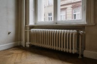 Alter Gliederheizkörper unter einem Fenster in einer Altbauwohnung