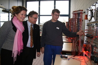 Die niedersächsische Kultusministerin Elisabeth Heister-Neumann und Regionspräsident Hauke Jagau lassen sich vom Berufsschüler Christian Fette die Schaltung einer Bremsbeleuchtung zeigen