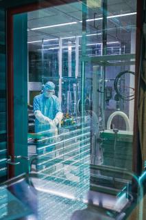 Der Blick in die Impfstoffabfüllung ist bei laufender Produktion nur hinter der Glasscheibe möglich. Die Mitarbeiter Björn Dalichau und Andreas Müller bereiten die Linie für die Abfüllung des SARS-CoV-2-Impfstoffkandidaten vor