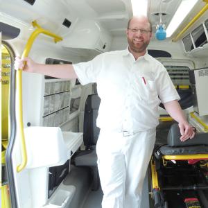 ICW-Wundexperte Mirko Mau steht im Innenraum des Wundmobils und versorgt hier die Wunden von Patienten.