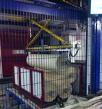 Der Roboter sortiert und kommissioniert die Textilrollen aus einem Behälter heraus, legt diese auf seinen Sortiertisch und gibt die Rollen in die Zielpalette hinein.