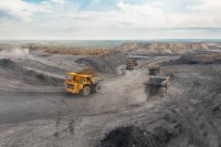 Electric haul trucks navigate around a mining site. At present, just 0.5% of mining equipment is electrified.