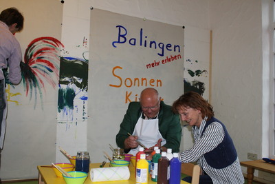 Landrat Günther-Martin Pauli und Oberbürgermeister Helmut Reitemann testen mit Leiterin Karina Matthes die Malwand im Sonnenkinderland