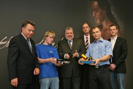 Pressefoto: Ministerpräsident Kurt Beck (mitte), zusammen mit Dr. Josef Staub (links) und vier Auszubildenden zu Besuch bei Schneider-Kreuznach in Bad Kreuznach