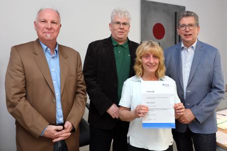 (von links): Stefan Thiele (Aufsichtsperson der BGHM), Christoph Schneider (Betriebsrat Saarstahl AG) und Roman Selgrath (Geschäftsführer GBQ) gratulieren der Lebensretterin Marion Asante / (Copyright: Saarstahl AG)
