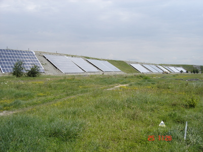 Solarzellen zum Einfangen der Sonnenenergie, säumen den aufgeschütteten Rand des Wärmespeichers.