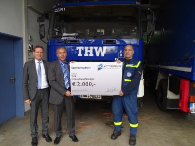 (v. l.) Personalleiter Heiko Göttler und Logistikleiter Jürgen Nowack, beide von MS Motorservice International GmbH, überreichen Jens Weihbrecht vom THW einen Spendenscheck als Dank für den enormen Einsatz beim Unwetter am 18. August